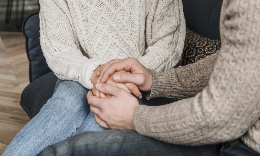 couple-holding-hands-sofa couple-holding-hands-sofa